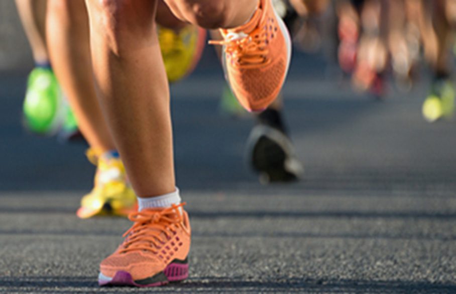 Ihmiset juoksevat asfaltilla.